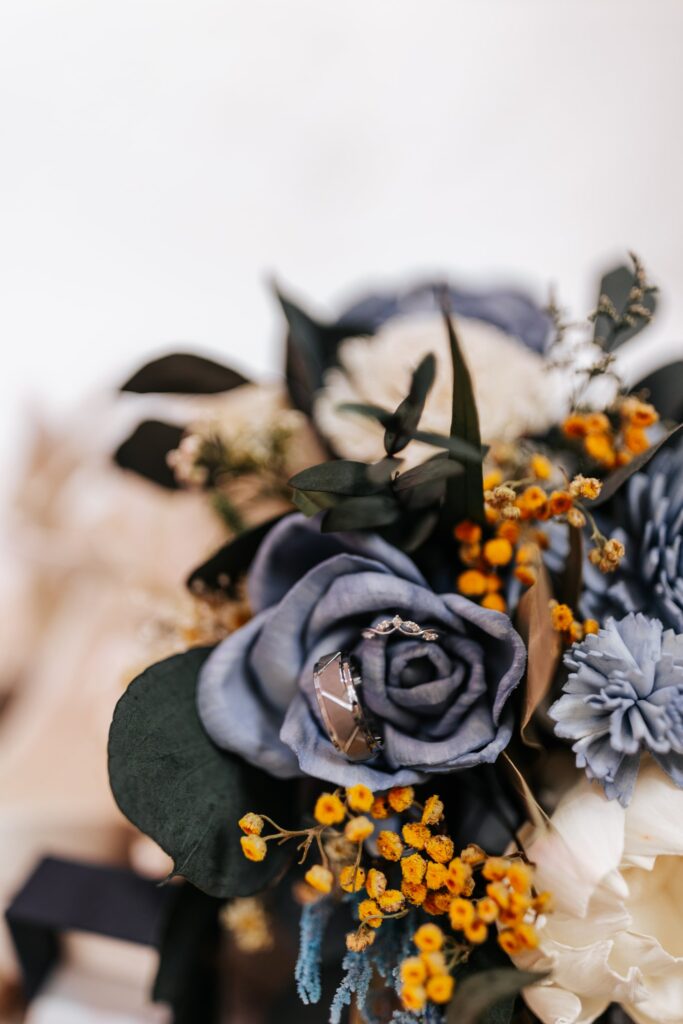 Overview of a bouquet made with blue, navy, and orange wood flowers.