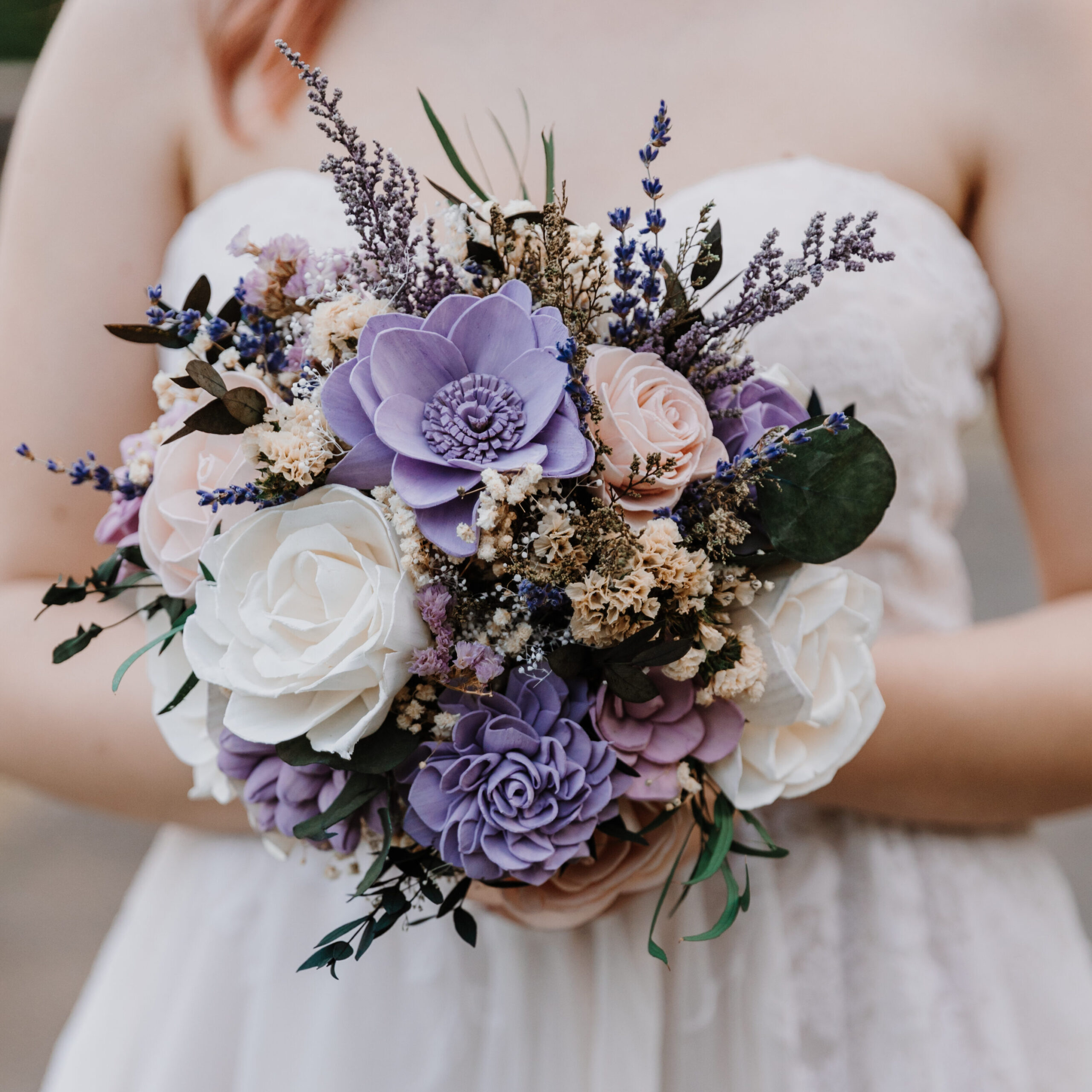Photograph of a medium sized bridal bouquet featuring a modern and loose style with purple, white, and pink sola flowers