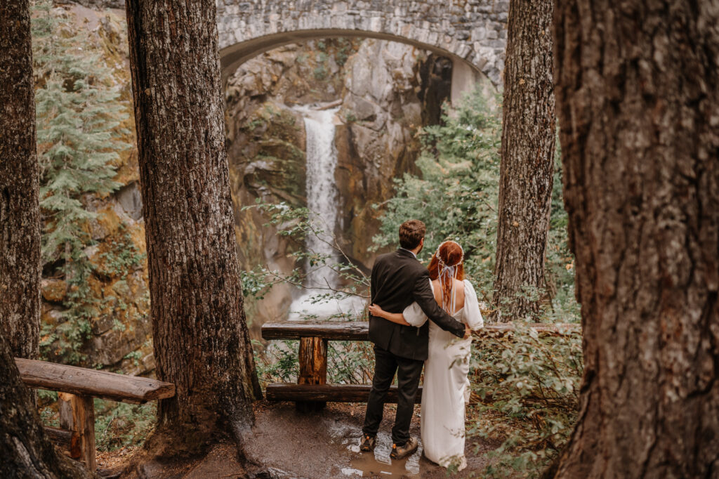 Couple embracing while looking at a gorgeous waterfall. 