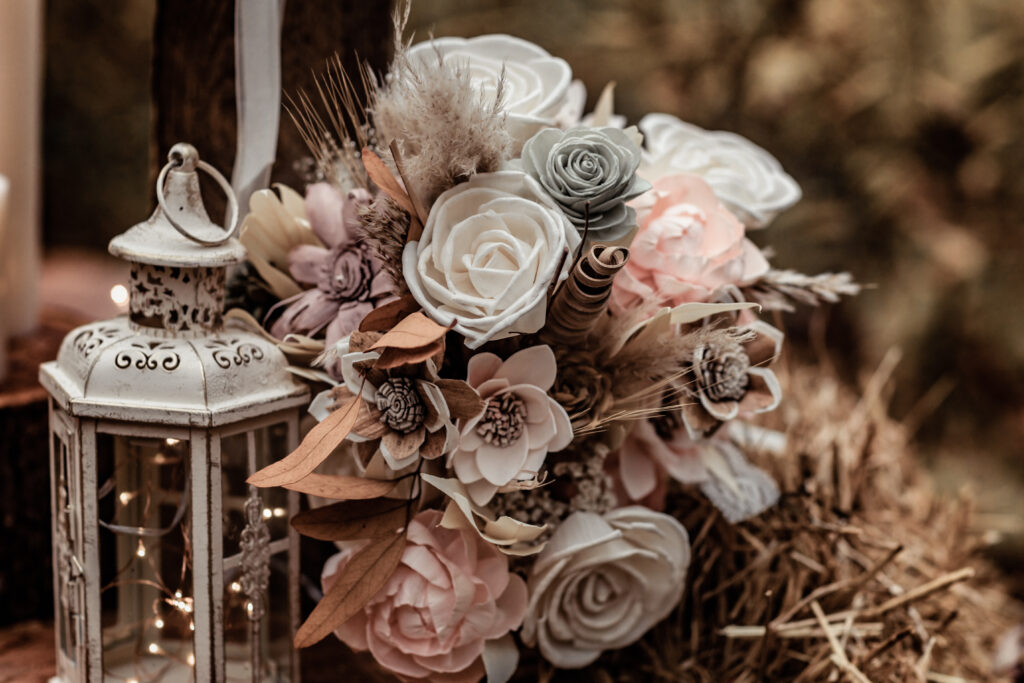 A neutral toned wedding bouquet with pink, blue, and cream pastel flowers.