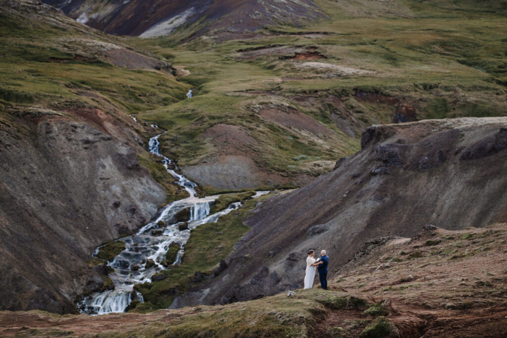 Couple exchanging vows during their ceremony at a waterfall in Iceland