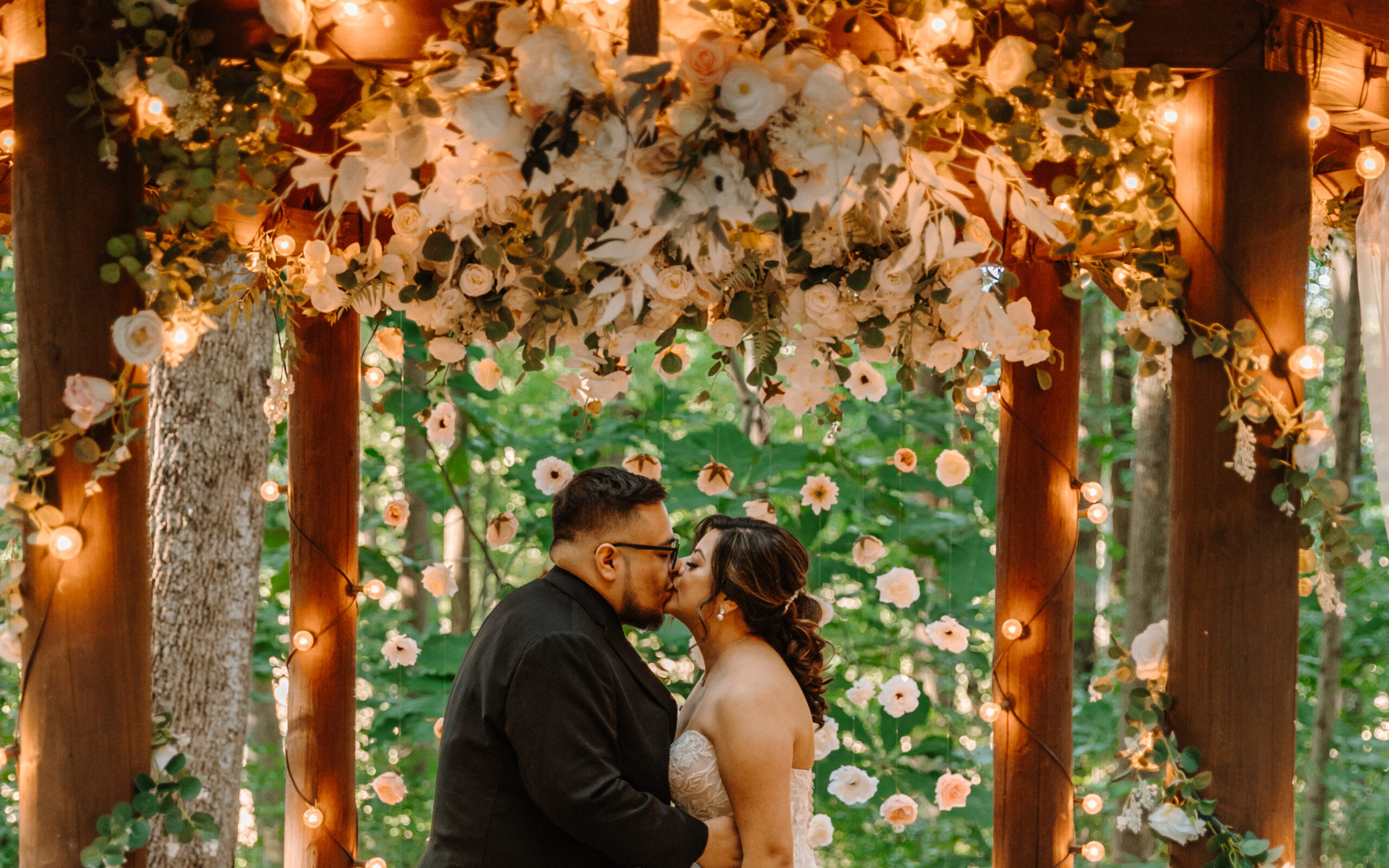 A stunning arbor and dangling flower backdrop made of silk faux flowers. 