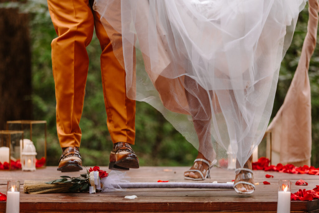 Couple preforming an unconventional  broom jumping on their wedding day.