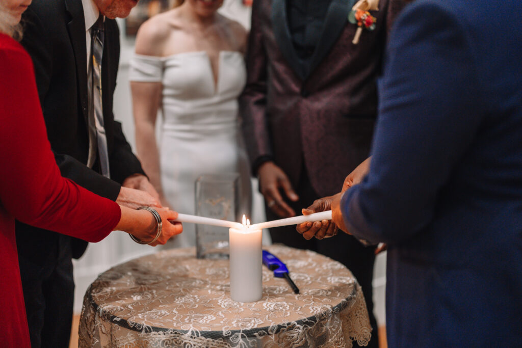 Couple preforming a unity candle ceremony on their wedding day.