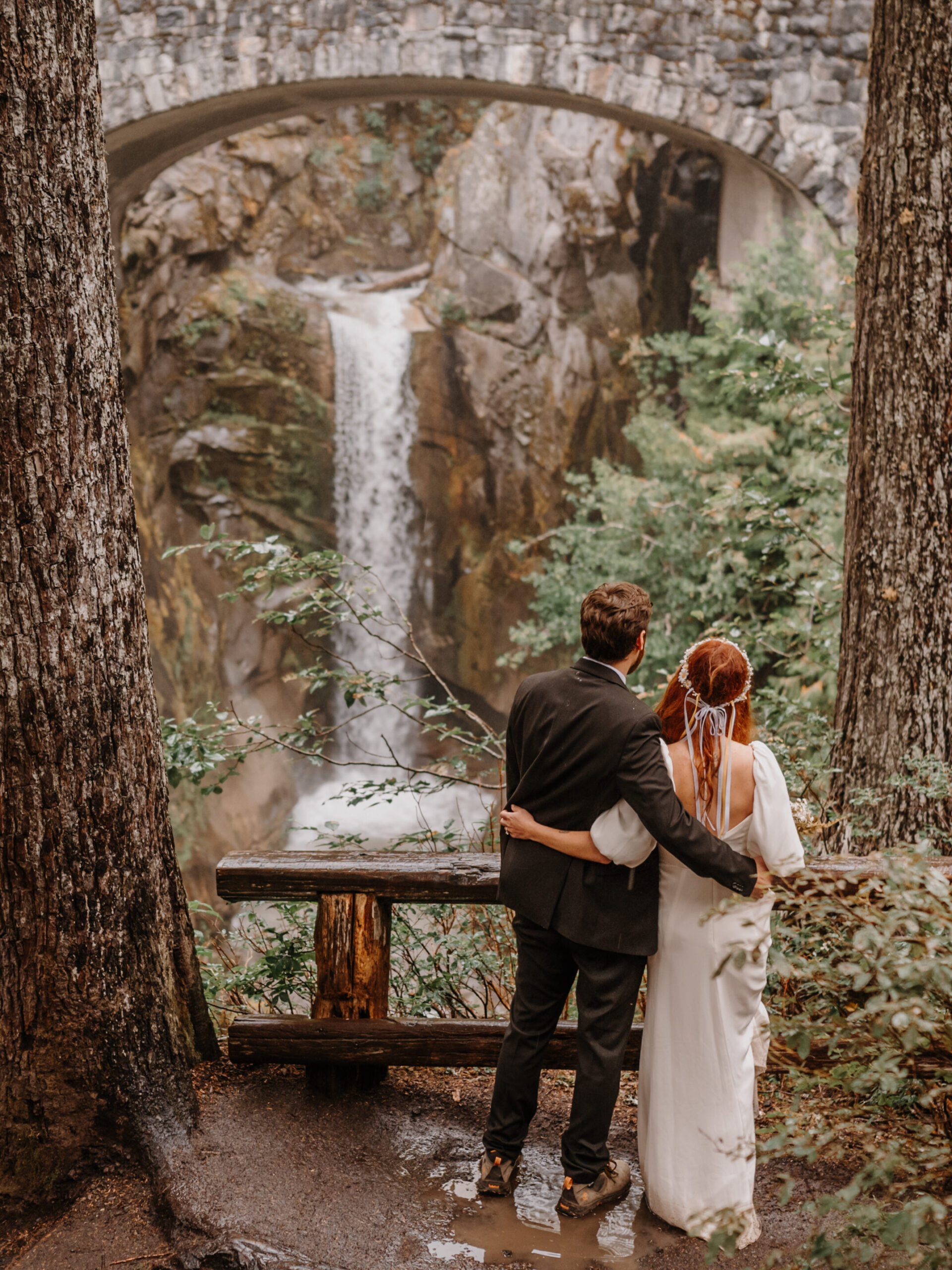 Couple embracing while looking at a gorgeous waterfall.