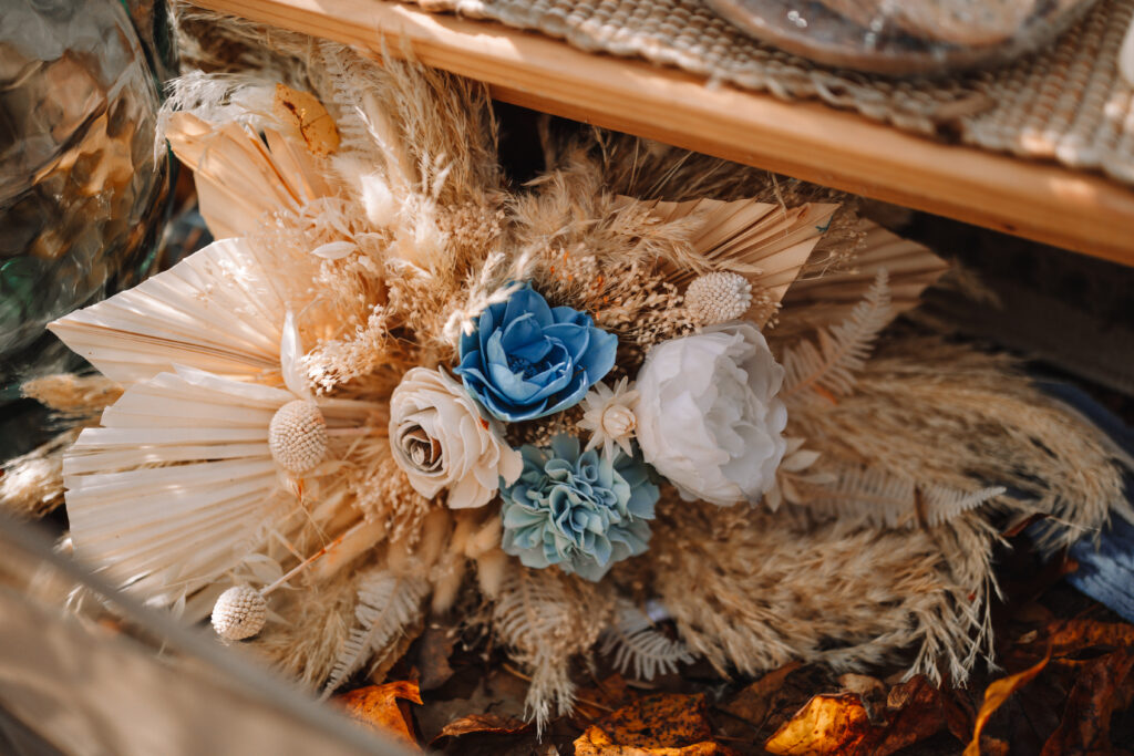 A beautiful bohemian floral table arrangement with pampas grass and blue flowers.